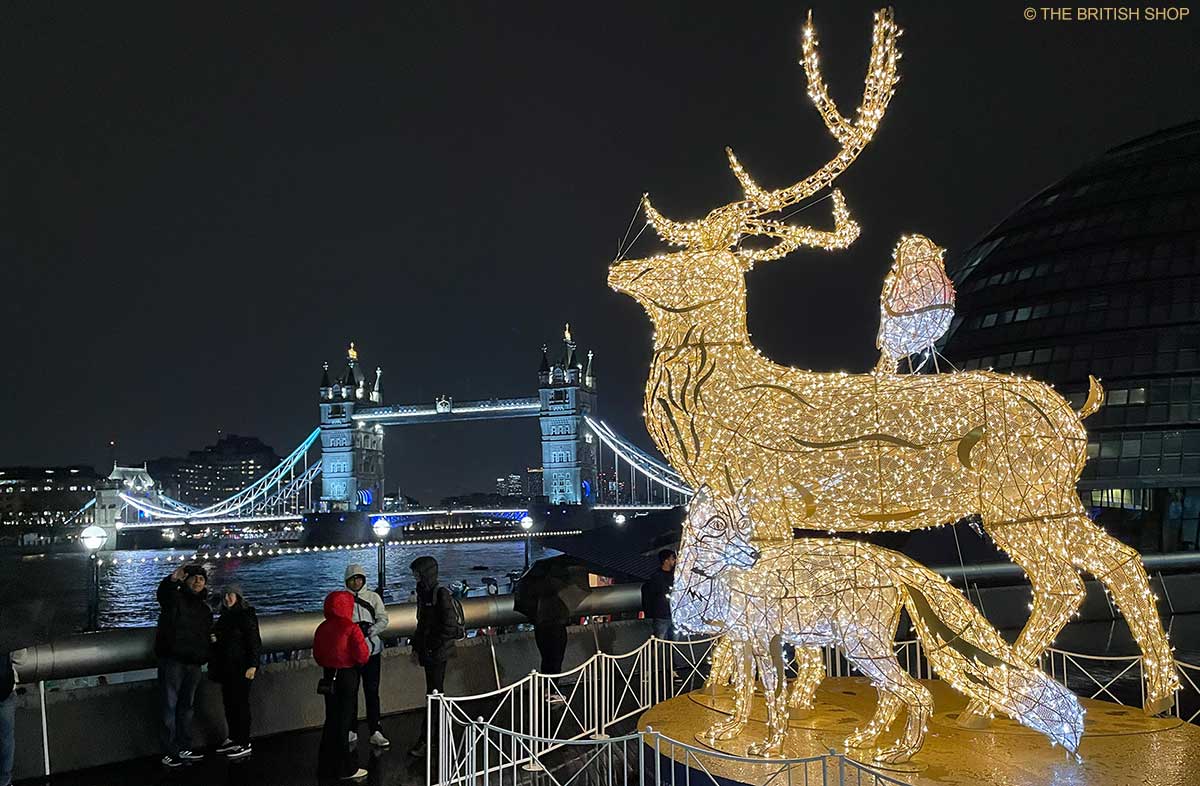 Nachgebildete Tiergestalten, ein Hirsch, ein Rotkehlchen und ein Fuchs, leuchten beim Weihnachtsmarkt "Christmas by the River". Im Hintergrund ist die Tower Bridge zu sehen.