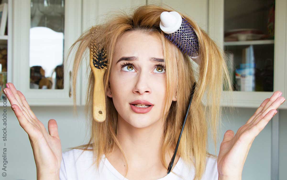 Eine junge Frau mit zwei Bürsten im Haar