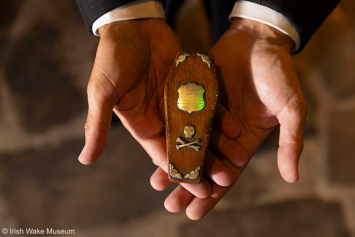 Miniatur-Sarg wird in zwei Händen gehalten Miniatur-Sarg wird in zwei Händen gehalten