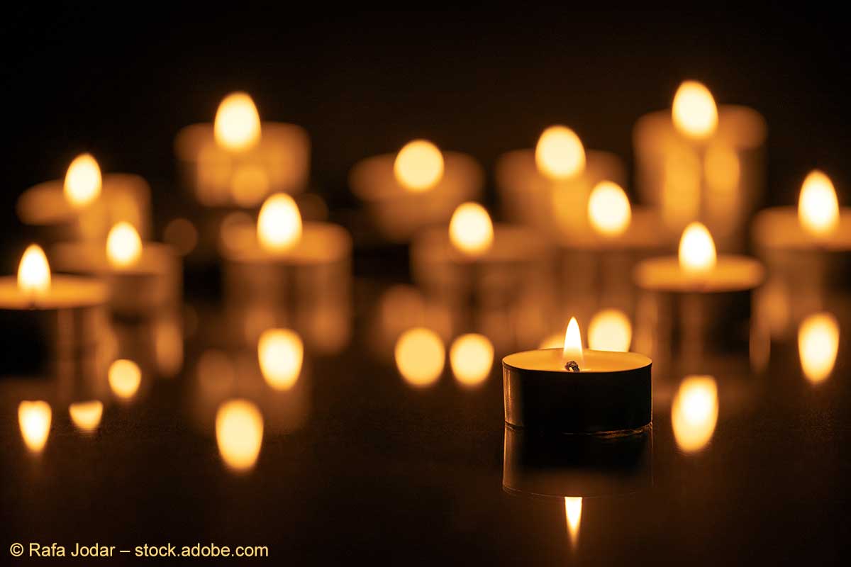 Eine Vielzahl angezündeter Teelichte vor einem dunklen Hintergrund